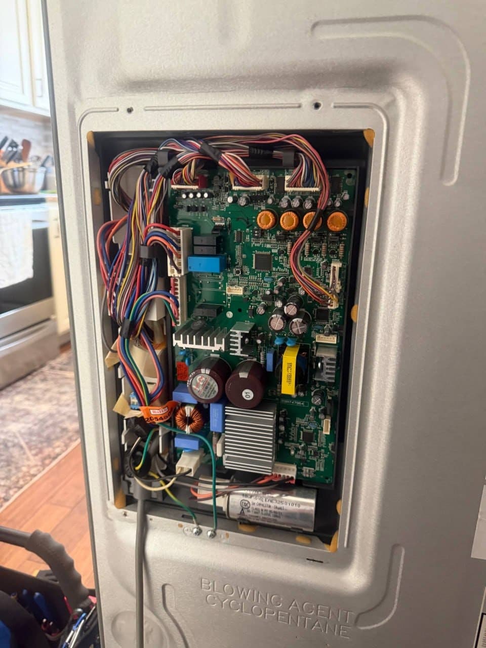 The new refrigerator control board wired and installed in place