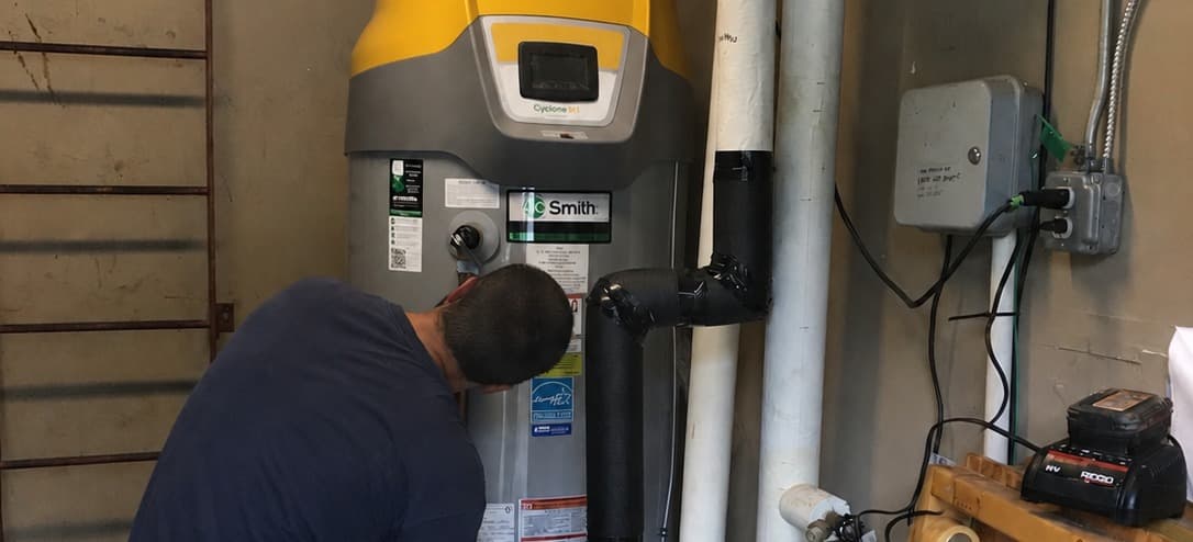 Technician inspecting the label on a residential gas water heater